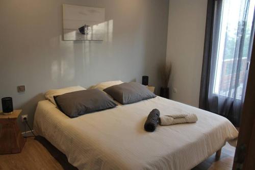 a bedroom with a bed with a shoe on it at Maison calme IHESA in Bidache