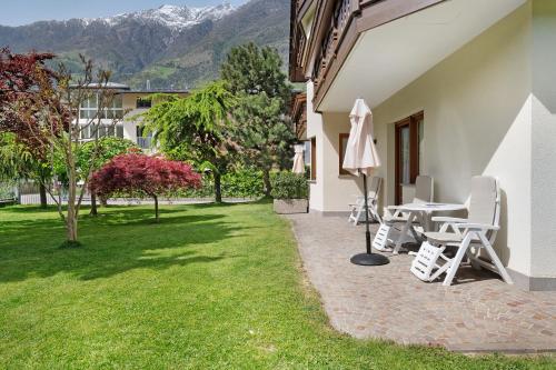 a patio with a table and chairs and a lawn at Mayr Apartments Zwei in Plaus