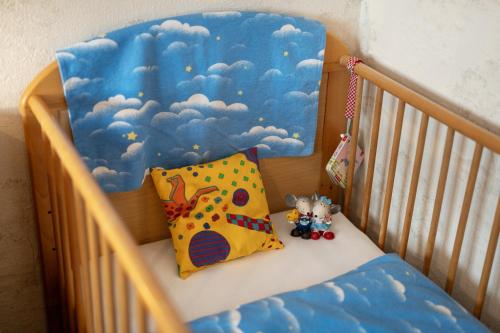 a crib with a pillow and stuffed animals in it at Ferienwohnung Berghansenhof in Wolfach