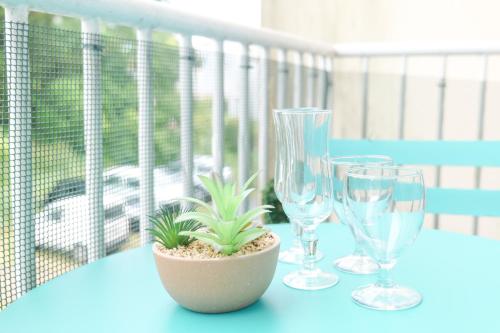 trois verres à vin et une plante en pot sur une table dans l'établissement Studio au calme avec balcon Port Olona les Sables 4 personnes, à Les Sables-dʼOlonne