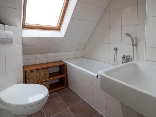 a bathroom with a toilet and a tub and a sink at Alte Wäscherei in Spiekeroog