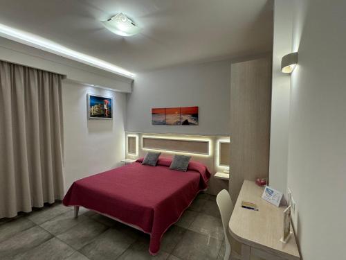 a bedroom with a bed with a red blanket at B&B Holiday Tropea in Tropea