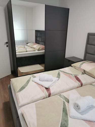 twee bedden in een kamer met handdoeken erop bij Apartman Juric in Posušje