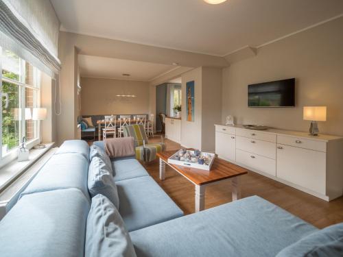 a living room with a blue couch and a table at Spiekerhorst in Spiekeroog