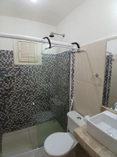 a bathroom with a shower and a toilet and a sink at Milano Hotel Pousada Canoa Quebrada in Canoa Quebrada