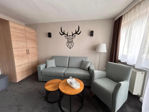 a living room with a couch and a table at Hotel Haus am Hochwald in Hahnenklee-Bockswiese