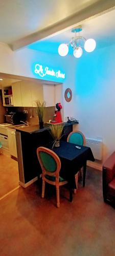 une cuisine avec une table et des chaises dans une pièce dans l'établissement gîte du jardin secret, à Saint-Valery-sur-Somme