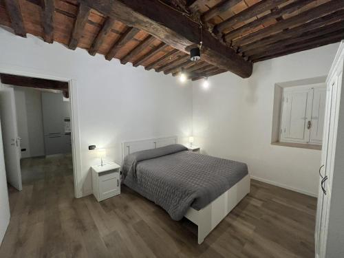 - une chambre avec des murs blancs et un lit avec deux lampes dans l'établissement I due Ciueli, à Pescia