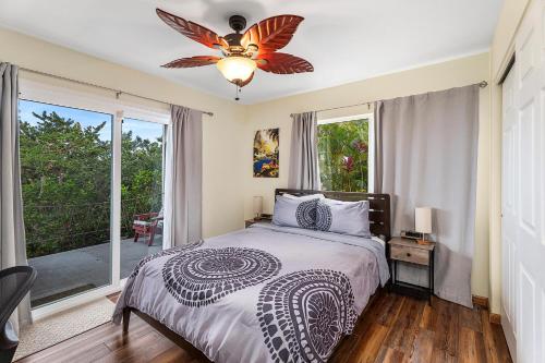 a bedroom with a bed and a ceiling fan at Hale Lio Kai in Kailua-Kona