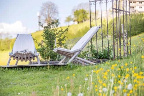 two chairs sitting in the grass next to a fence at Familienbauernhof Köss Schertler in Egg