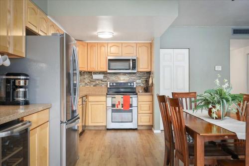 a kitchen with wooden cabinets and stainless steel appliances at Kona Plaza 212 in Kailua-Kona
