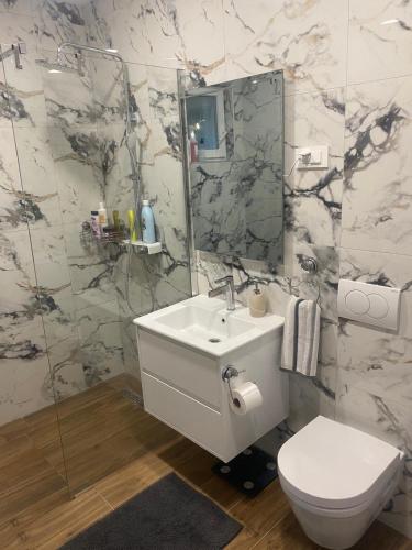 a bathroom with a sink and a toilet and a mirror at Apartman Telar in Vodice