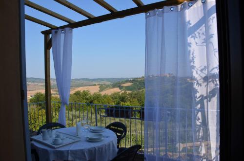 stół i krzesła na balkonie z widokiem w obiekcie FeWo CIELO mit Terrassen und und einen atemberaubenden Blick w mieście Terricciola