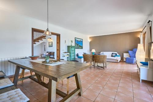 a dining room with a table and a living room at Finca Miralu in Calonge
