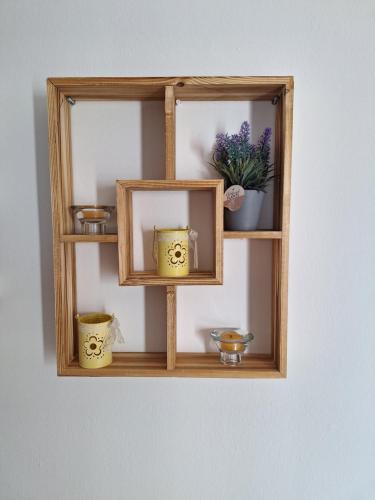 a wooden shelf with bowls and vases on it at Marena 2 in Makry Gialos