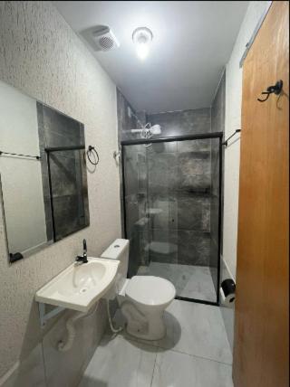 a bathroom with a toilet and a sink and a shower at Flat completo Aparecida de Goiânia in Aparecida de Goiania