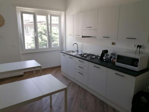 a kitchen with white cabinets and a microwave at Appia Garden in Rome