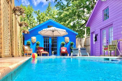 a house with a swimming pool in front of a purple building at Palazzo Hudson - Luxury Pool, Hot Tub, and Sauna in Hudson