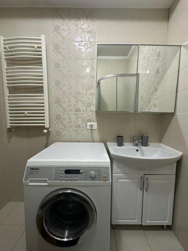y baño con lavabo y lavadora. en Renthouse Apartments - Feel Like Home, en Chişinău