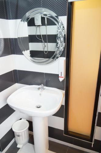 a bathroom with a sink and a mirror at Ma Non Nont Hotel & Apartment in Nonthaburi