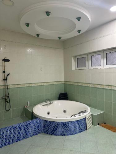 a large bathroom with a tub and a shower at May Weather Resort in Bukhara