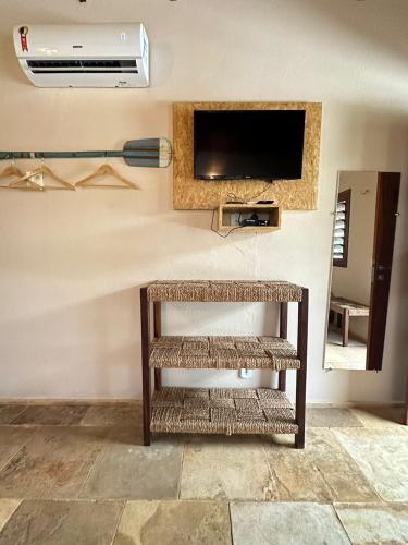 a living room with a tv on a wall at Pousada Vento do Kite in Barra Grande