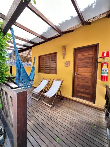 a deck with chairs and a hammock on a house at Pousada Vento do Kite in Barra Grande