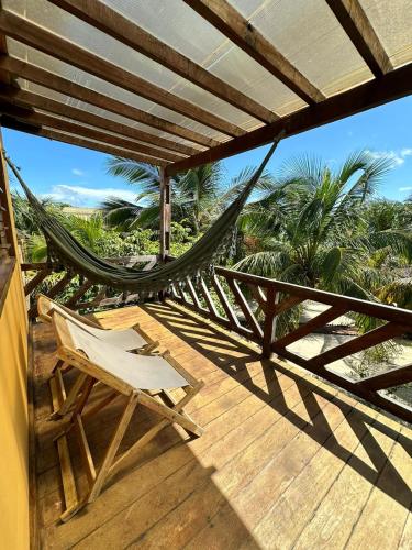 a hammock and a chair on a porch at Pousada Vento do Kite in Barra Grande