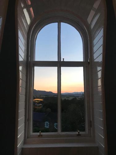 an arched window with a view of the sunset at Leven House Bed and Breakfast in Crieff