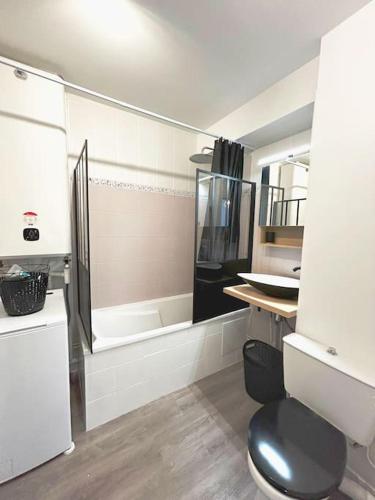 uma casa de banho com um chuveiro, um WC e um lavatório. em Appartement cosy avec terrasse et parking, 4 pers. em Étampes
