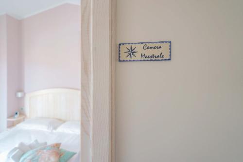 a sign on a wall next to a bed at La rosa dei venti in Villasimius