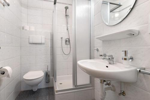 a white bathroom with a sink and a shower at Mayr Apartments Eins in Plaus