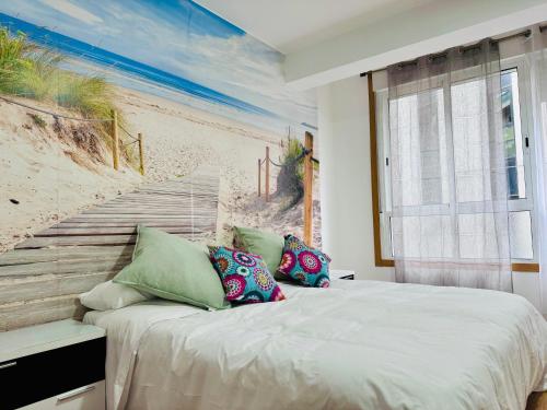 a bedroom with a bed with a painting of the beach at ¡VIVA VIGO! Tu escapada perfecta in Vigo