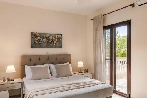 a bedroom with a bed and a sliding glass door at Villa Skala View in Skala Kefalonias