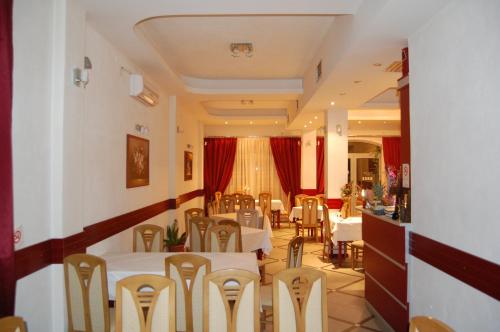 a restaurant with white tables and chairs and red curtains at Villa Rimari in Ohrid