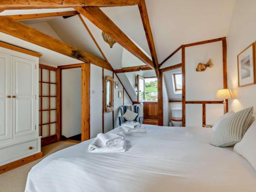 Torcrossにある3 Bed in Torcross 93956の木製の梁がある客室で、白い大型ベッド1台が備わります。