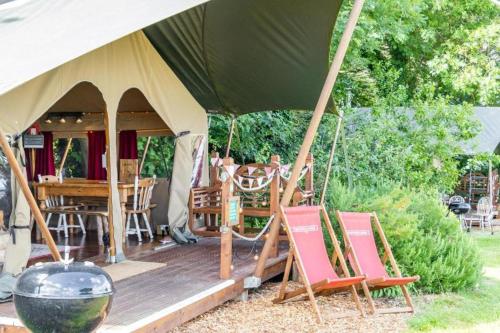 a gazebo with chairs and a table in it at Safari Tent 5 With Log Burning Tub At Tapnell Farm in Yarmouth