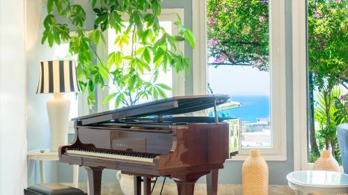 a piano sitting in a room with a window at Hotel Sinuessa Terme in Mondragone