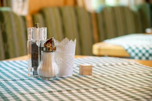 a table with a bottle of salt and a candle at Landgasthof Hanselewirt in Schwangau