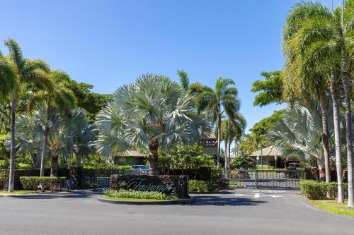 a parking lot with palm trees and a fence at Fairways at Mauna Lani #203 in Waikoloa