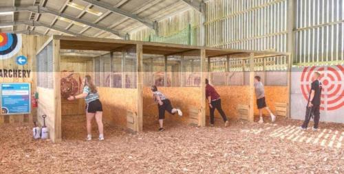 a group of people are painting a wall in a building at Safari Tent 5 With Log Burning Tub At Tapnell Farm in Yarmouth