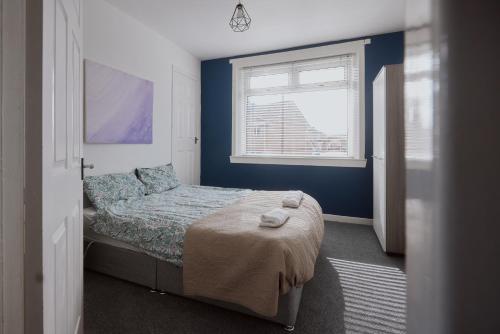 una piccola camera con letto e finestra di Modern And Vibrantly Designed Apartment a Motherwell