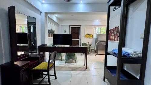ein Wohnzimmer mit einem Schreibtisch und einem TV in der Unterkunft Artgarden Juan dolio in Juan Pedro
