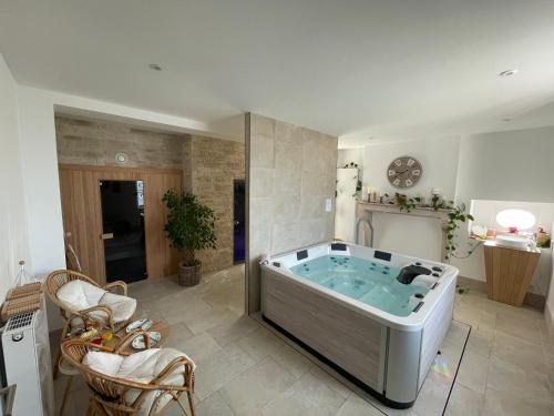 a large bathroom with a hot tub in a room at LE GOLURET Chambres & Table d'hôtes - Espace Bien Être in Couvignon