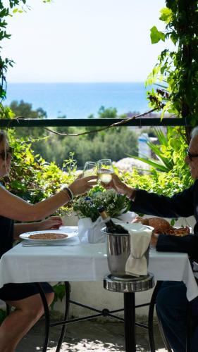 a group of people sitting at a table with food at Hotel Sinuessa Terme in Mondragone