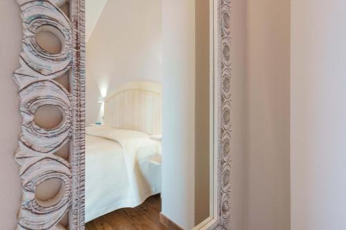 a mirror in front of a bedroom with a bed at La rosa dei venti in Villasimius