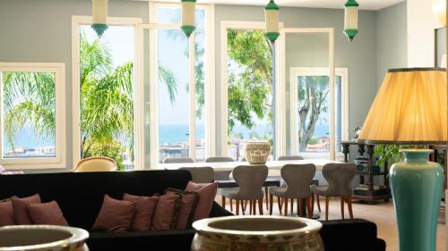 a living room with a couch and chairs and windows at Hotel Sinuessa Terme in Mondragone