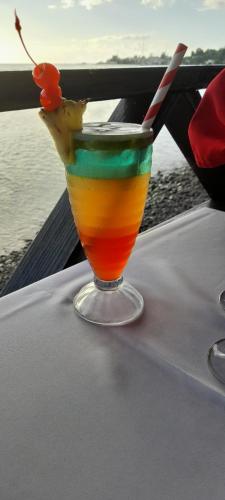a drink sitting on top of a table at Ocean's Edge Lodge Restaurant & Bar in Roseau