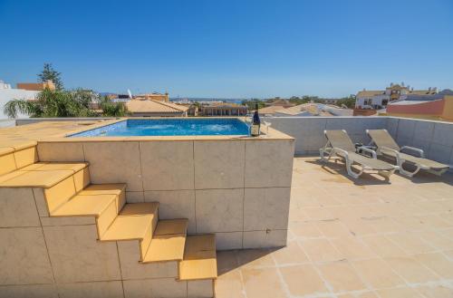 a swimming pool on a roof with a stairway next to avisor at B&B Dona Ana in Lagos