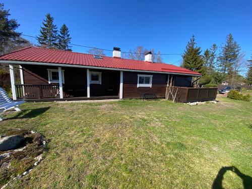 a small house with a red roof on a yard at Joosti Summer House in Käsmu